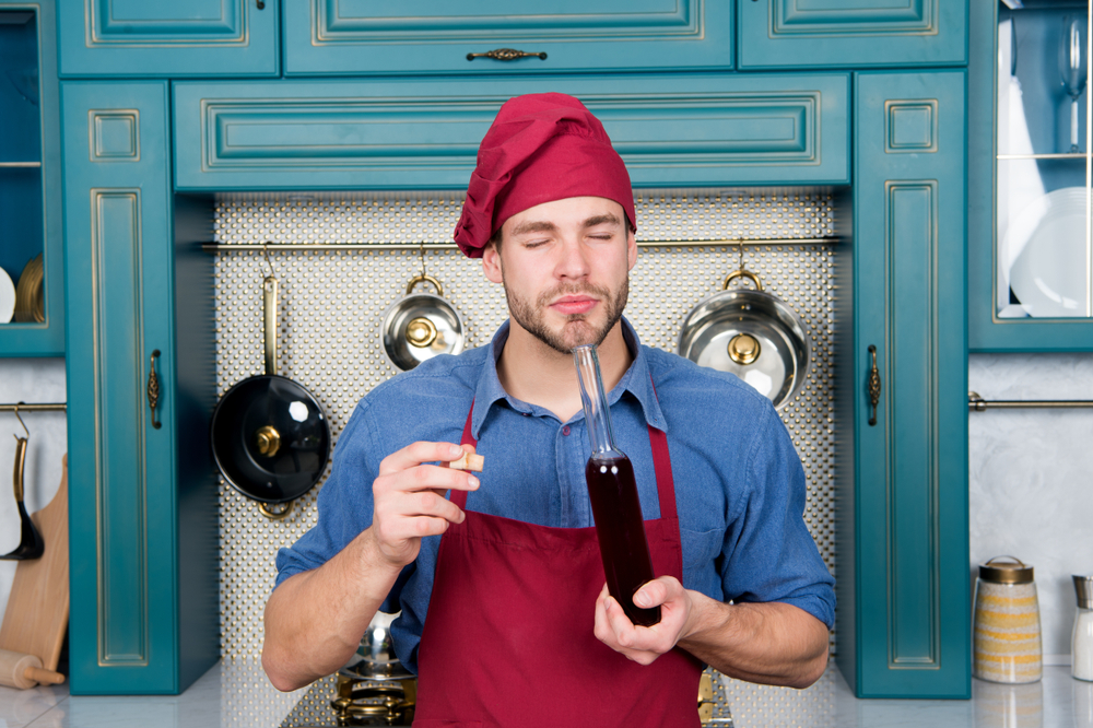 Cheff smelling red wine vinegar.