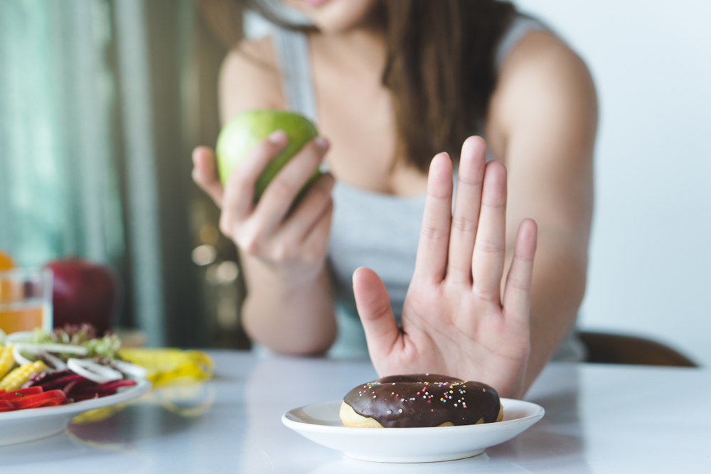 Woman saying no to donuts.