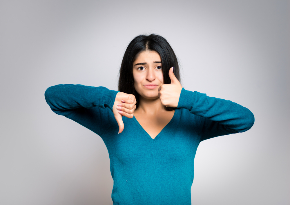 Woman showing thumbs up and down.