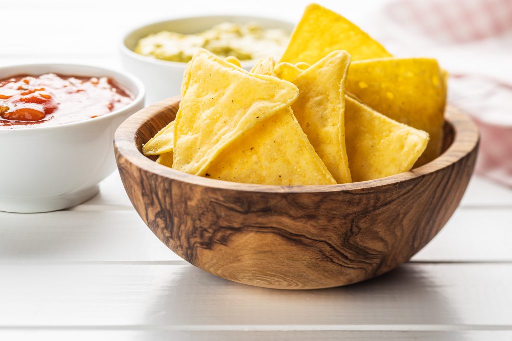 Corn nacho chips. Yellow tortilla chips in wooden bowl.