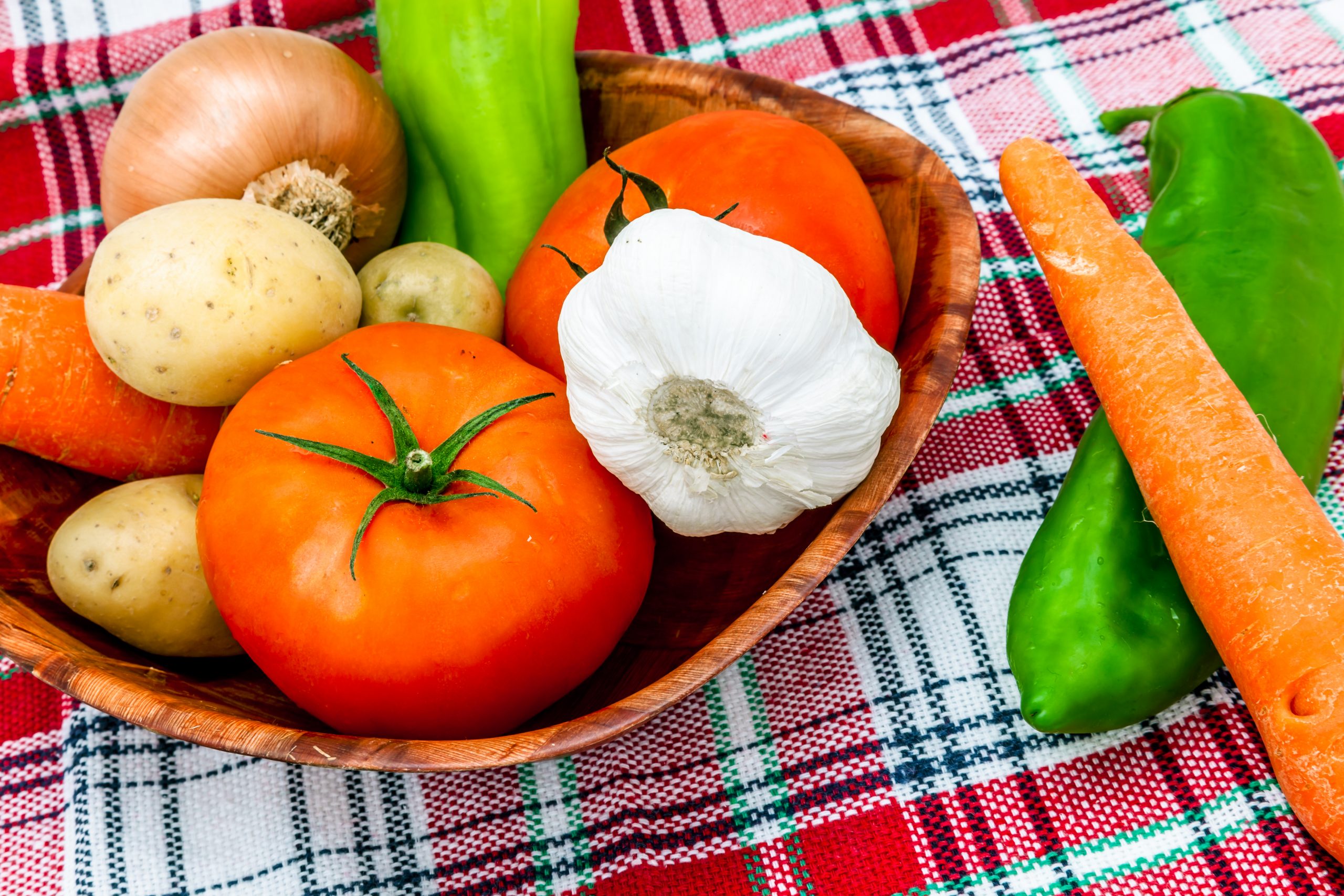 A wood dish with several fruits and vegetables