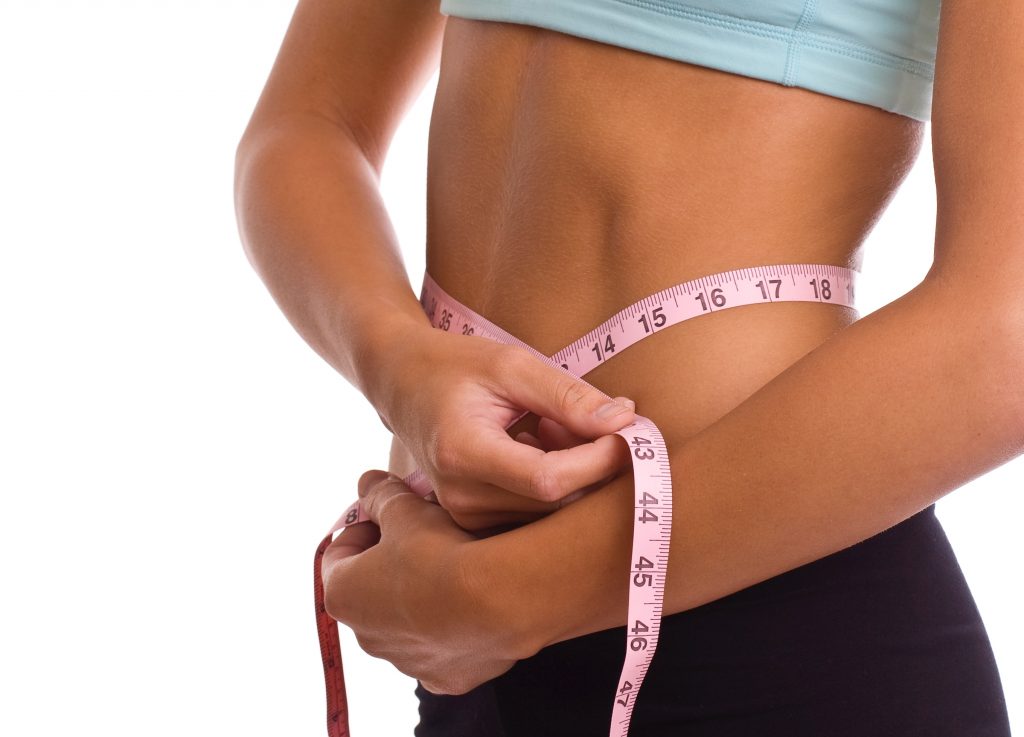 Woman measuring her waist.