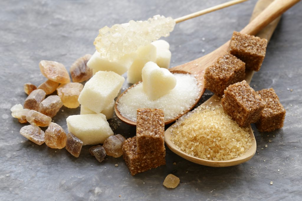 Spoons with different types of sugar.