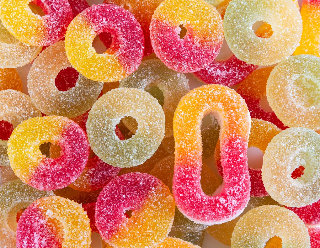 Chewing colorful marmalade in sugar.