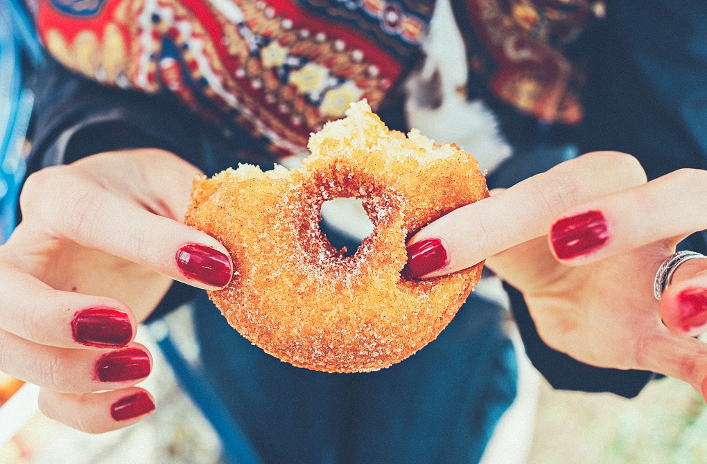 Woman holding doughnut. 