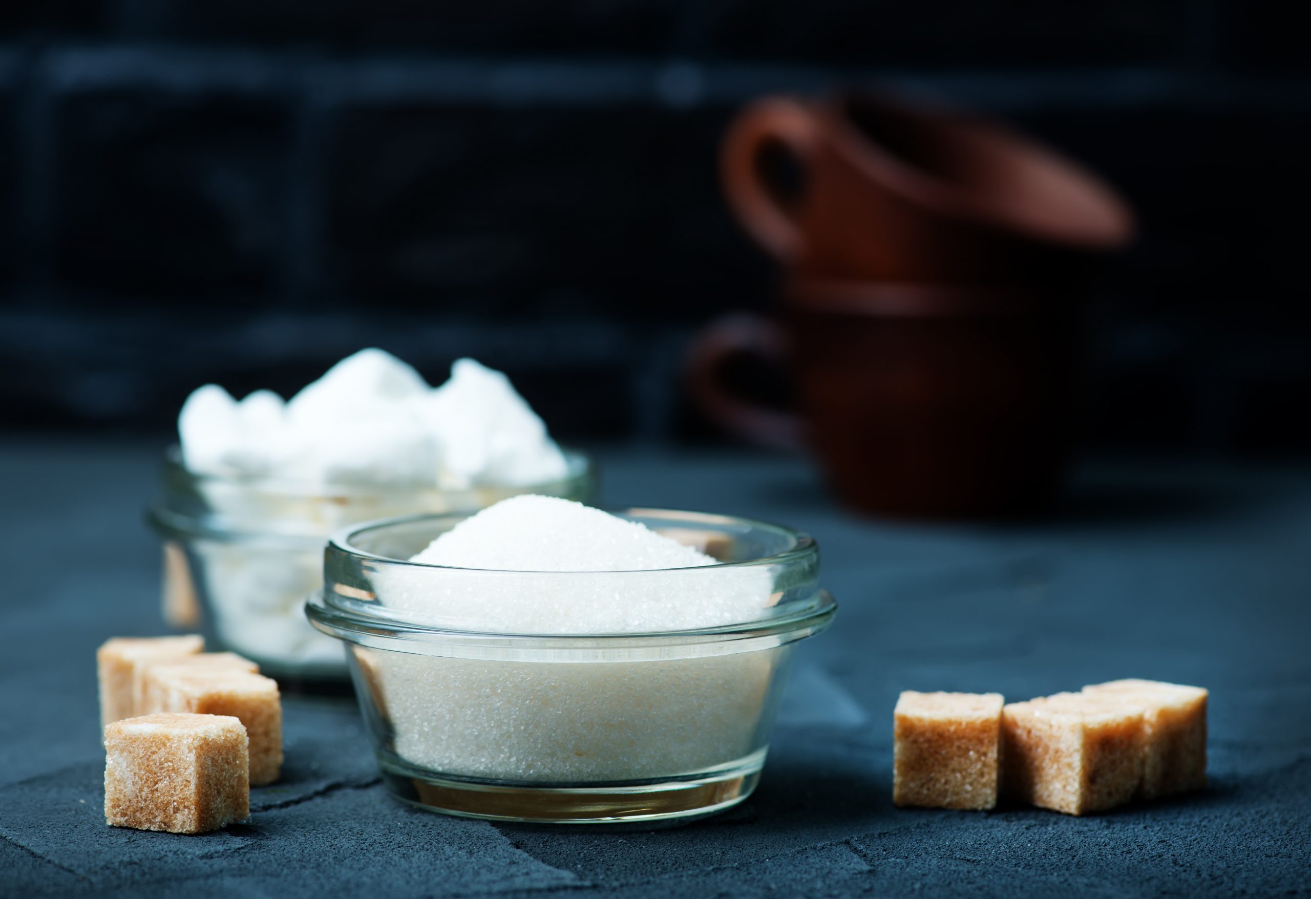 Sugar in bowl and on a table.