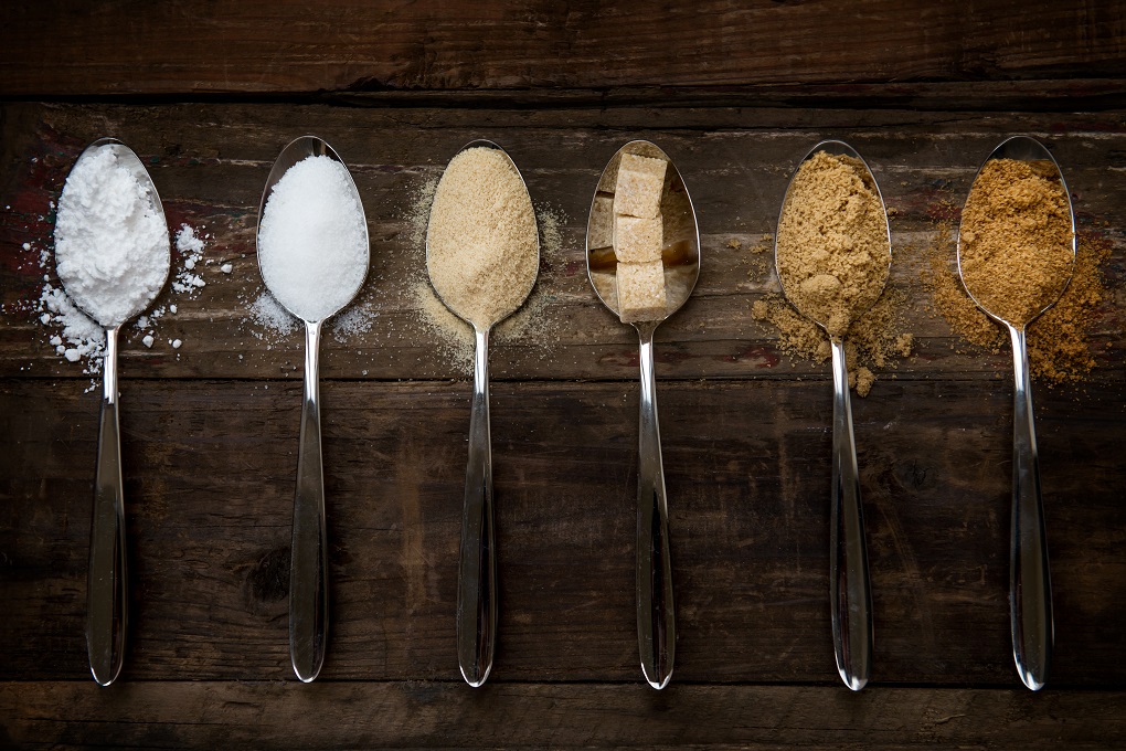 Different Kinds of Sugar in the Spoons, such as coconut sugar, pure cane sugar, icing sugar, agave syrup, dark brown soft sugar, golden caster sugar, demerara cubes