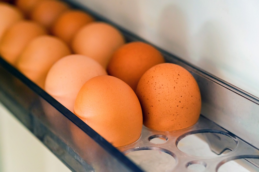 Close up of raw farm brown eggs in fridge. Selective focus