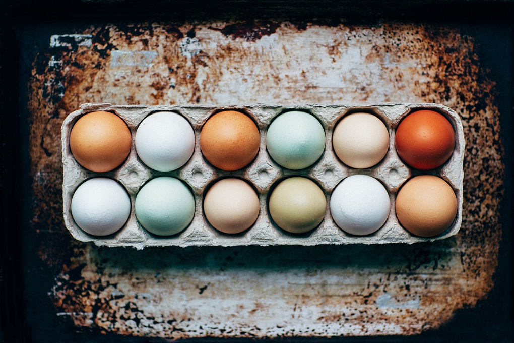 A carton of different colored eggs.