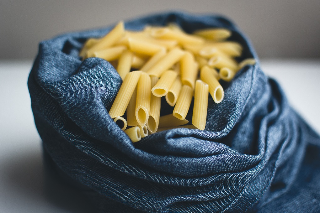 Detail of pasta penne in a blue linen