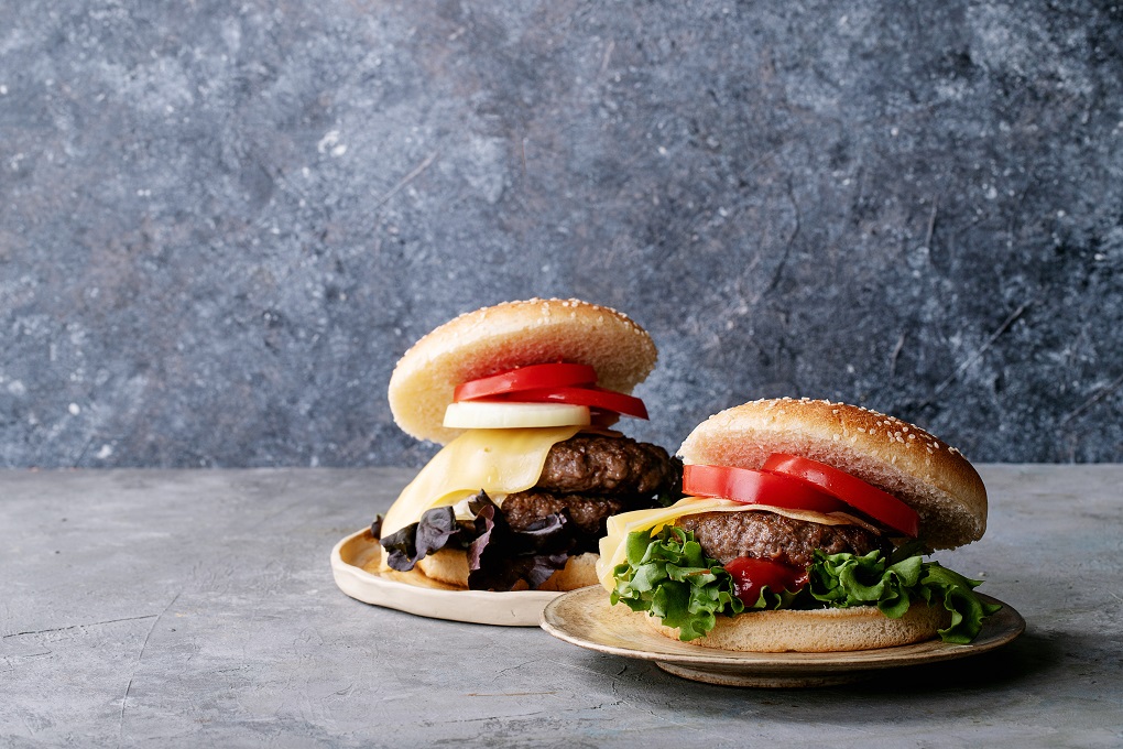 Homemade hamburger with fresh vegetables: lettuce, onions, tomato and ketchup