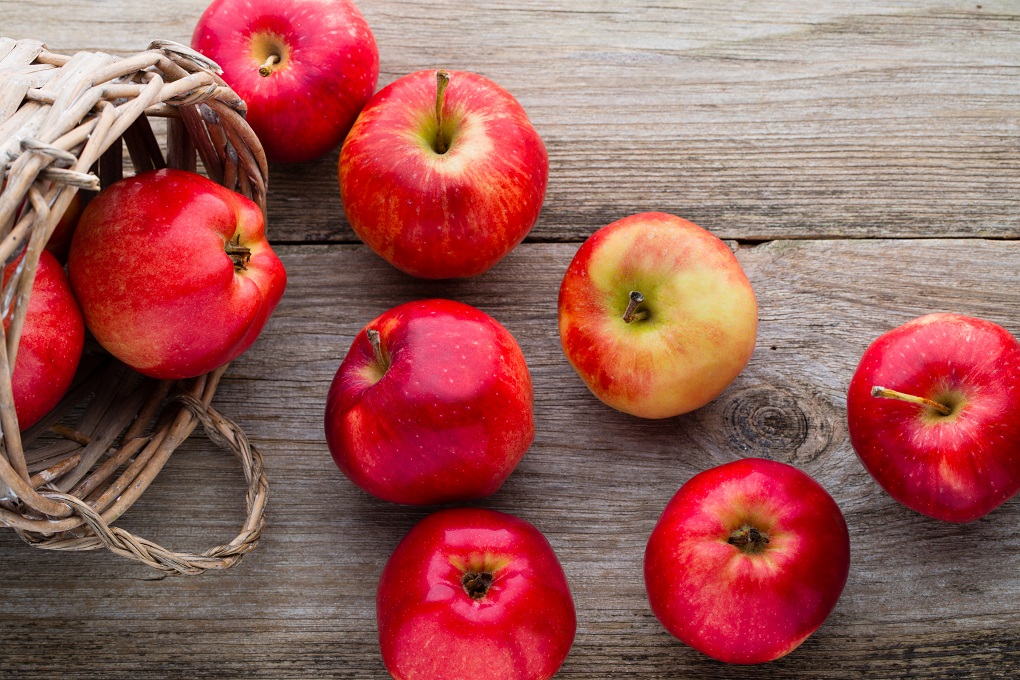 Ripe red apples on table close up.
