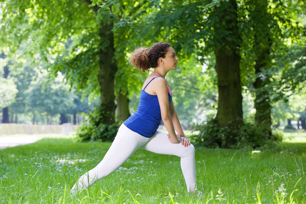 Young black woman stretching in the park